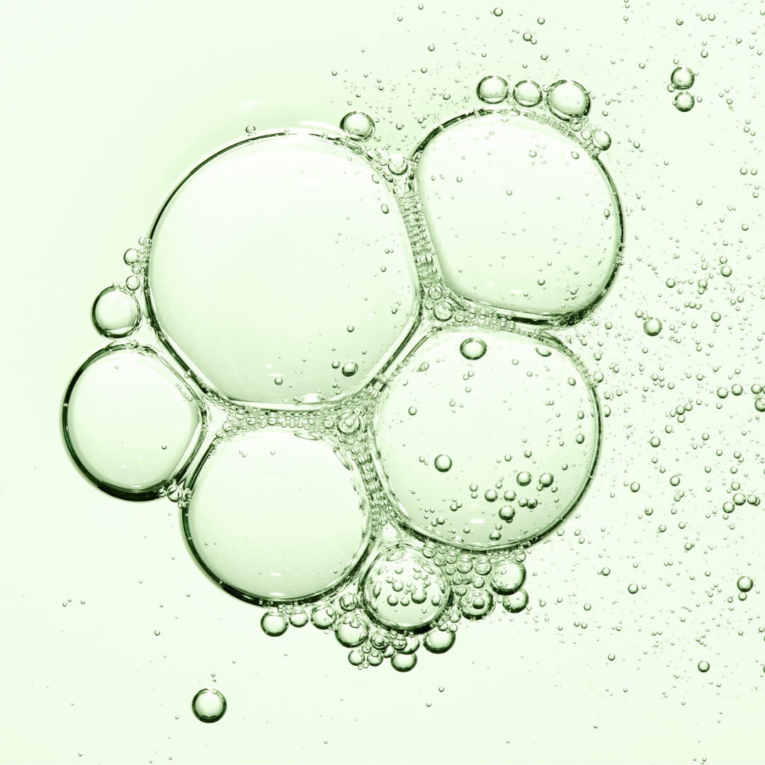 Closeup of bubbles on a light green background.